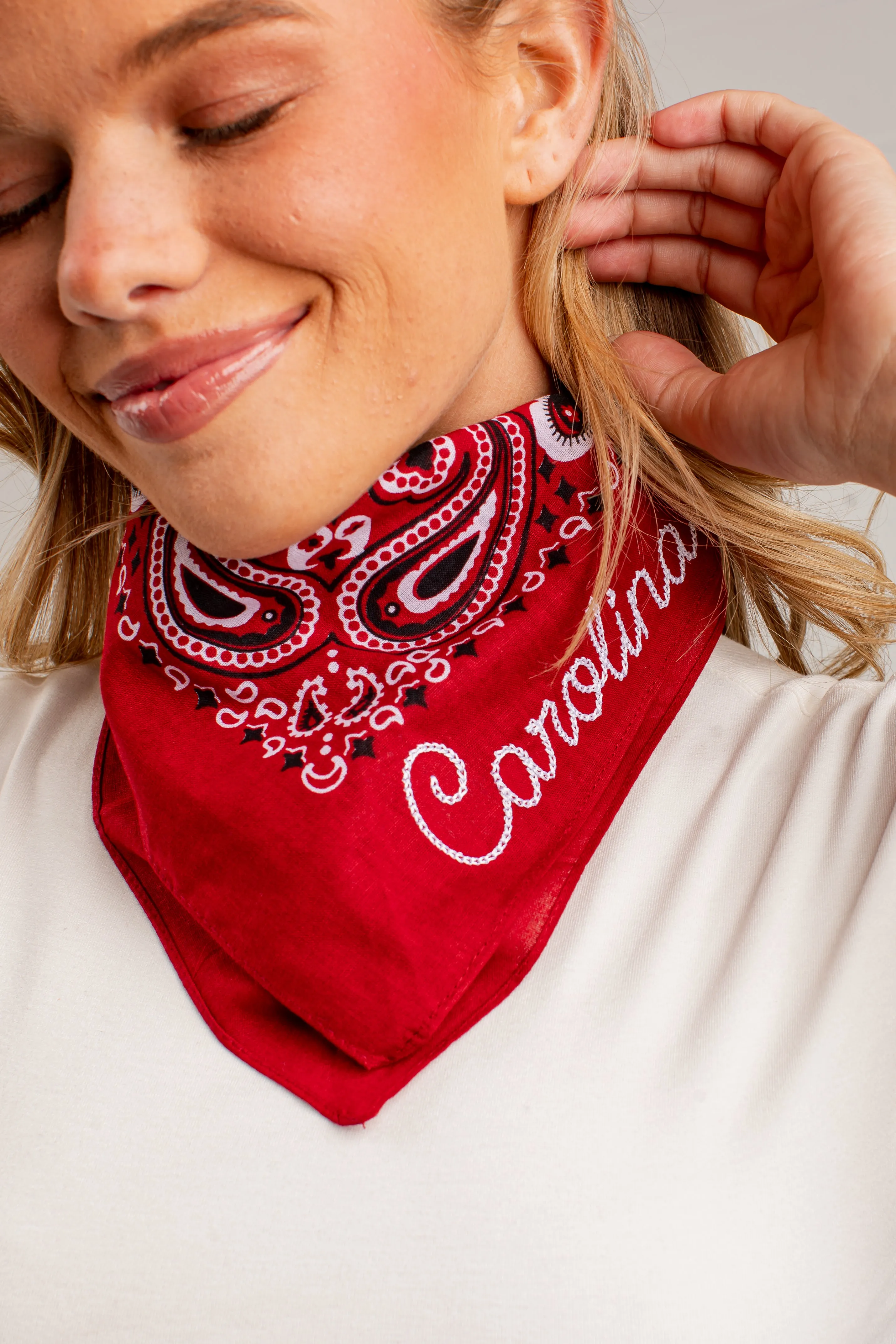 Wanita mengenakan bandana burgundy motif paisley dengan bordir tulisan Carolina putih eksklusif dari GAMPANG WD