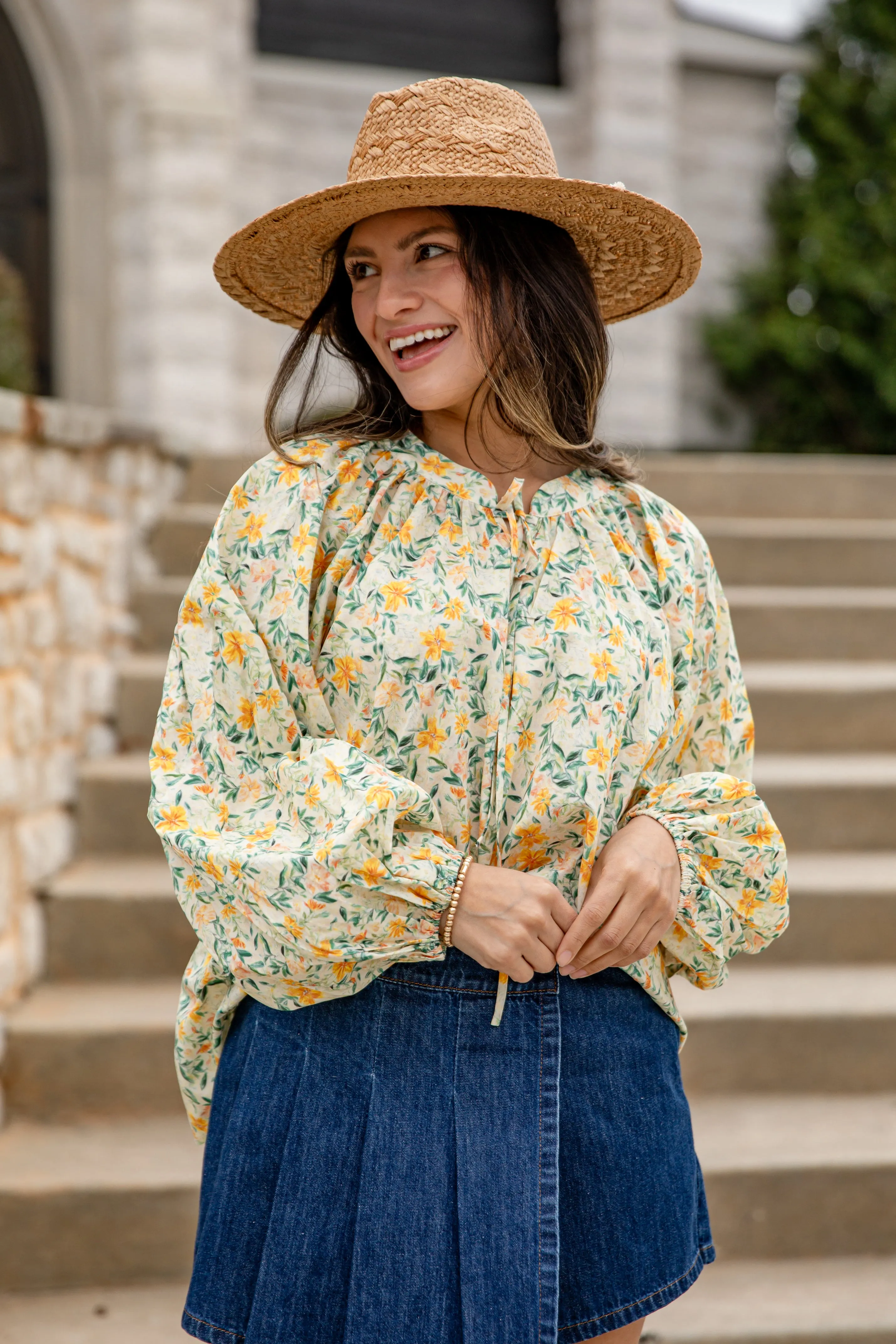 Wanita mengenakan blouse kuning motif bunga dan topi jerami di luar ruangan dari MELAYUPOKER