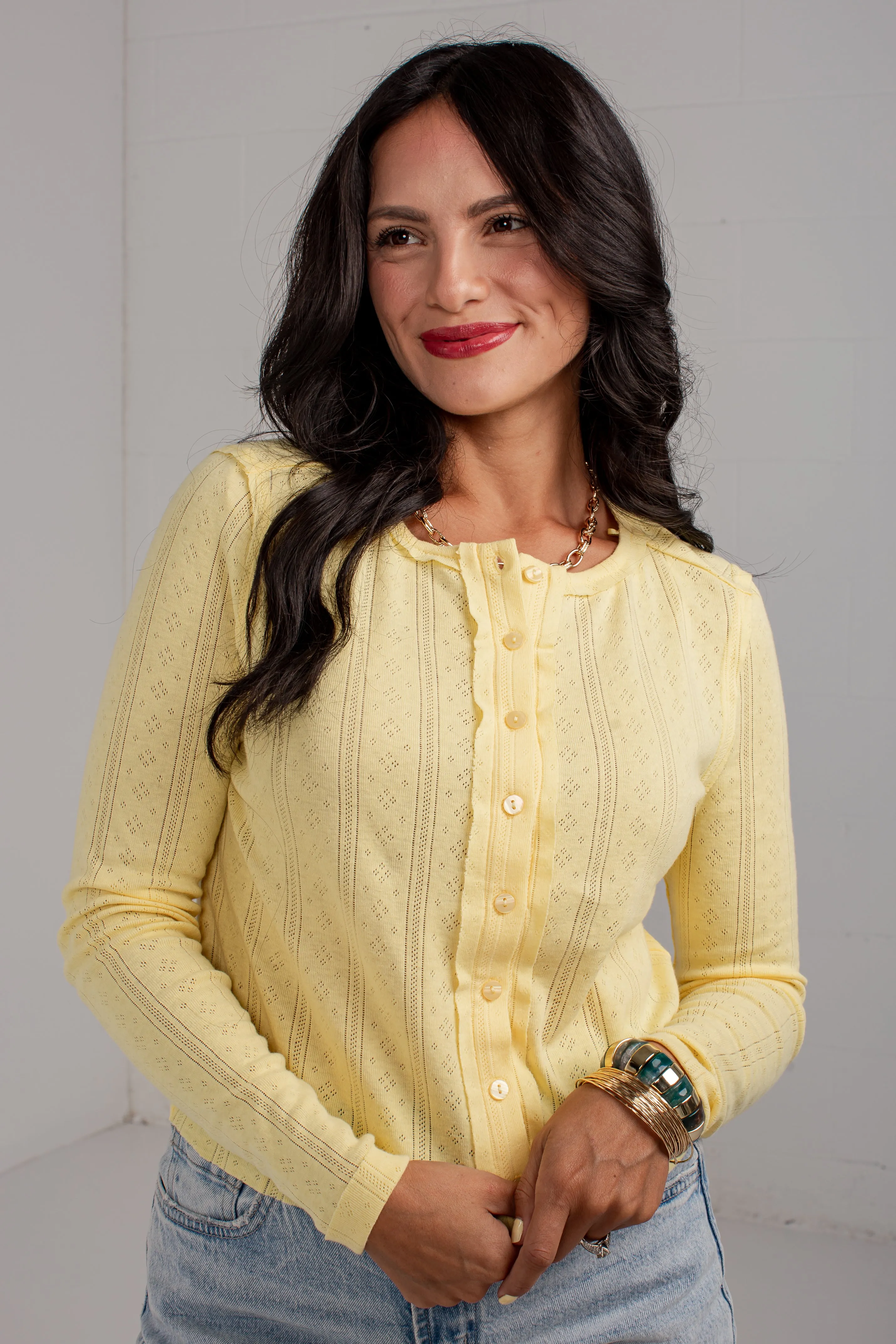 Wanita mengenakan cardigan rajut textured henley dari koleksi MAHIRTOTO